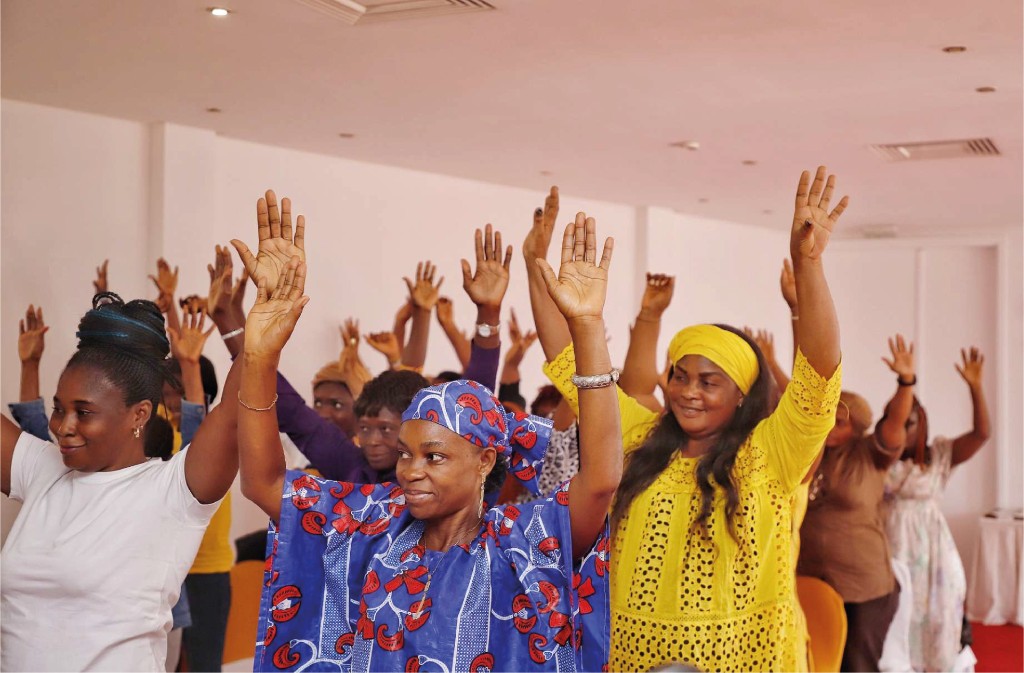 Women raising their hands together during a community gathering